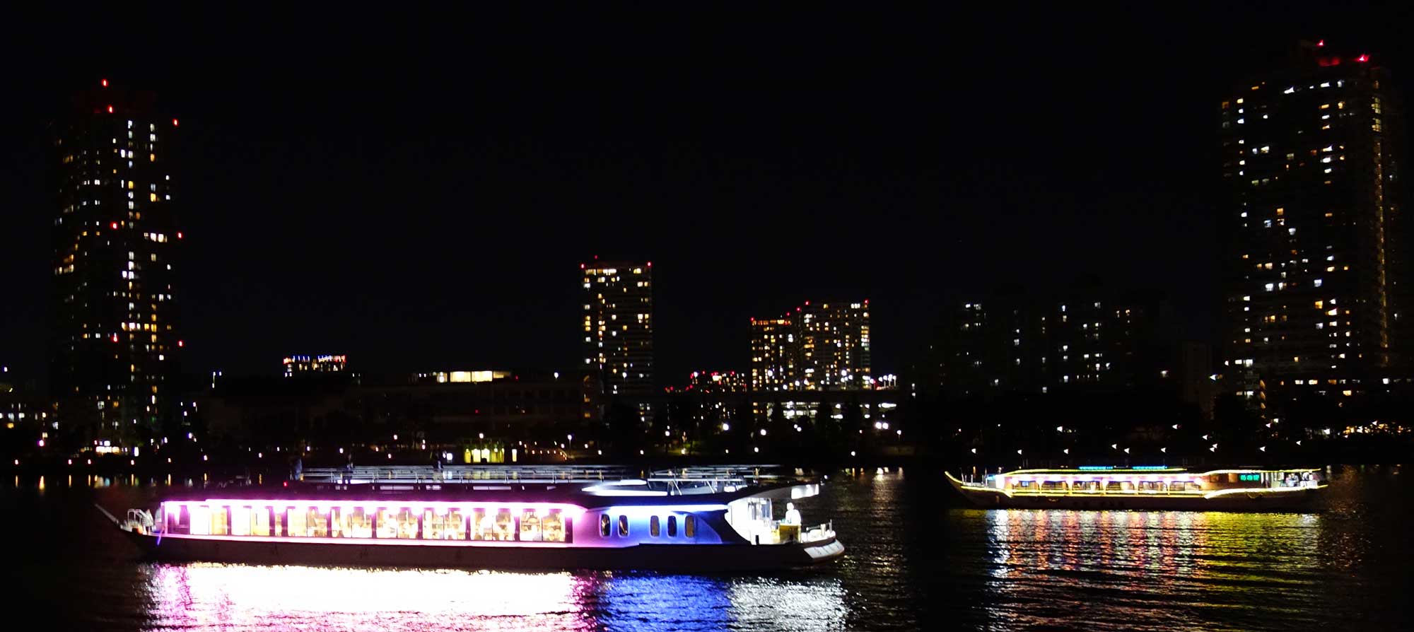 Традиционное судно-ресторанчик яката-бунэ в Токийском заливе на фоне ночного города
